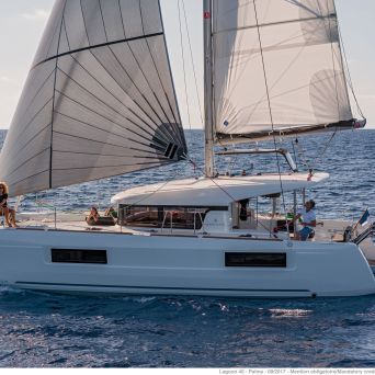 Catamaran sailboat sailing through open water peacefully during sunset